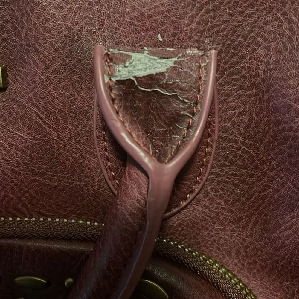 Steve Madden burgundy faux leather satchel with rustic studs accent.
